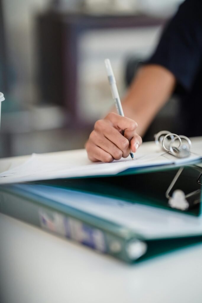 Focused image of a businesswoman writing notes in a professional office setting.
