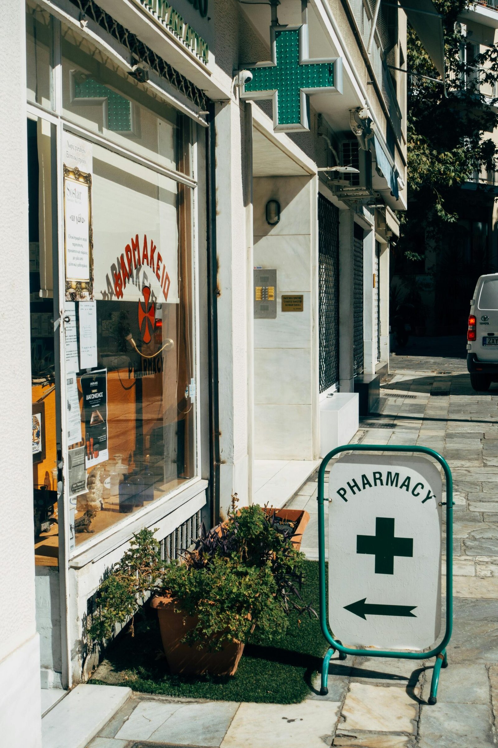 External view of a pharmacy with directional signage on a sunny day.