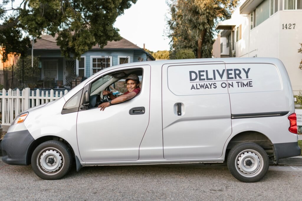 Courier driving a delivery van with 'Always On Time' service slogan parked in neighborhood.