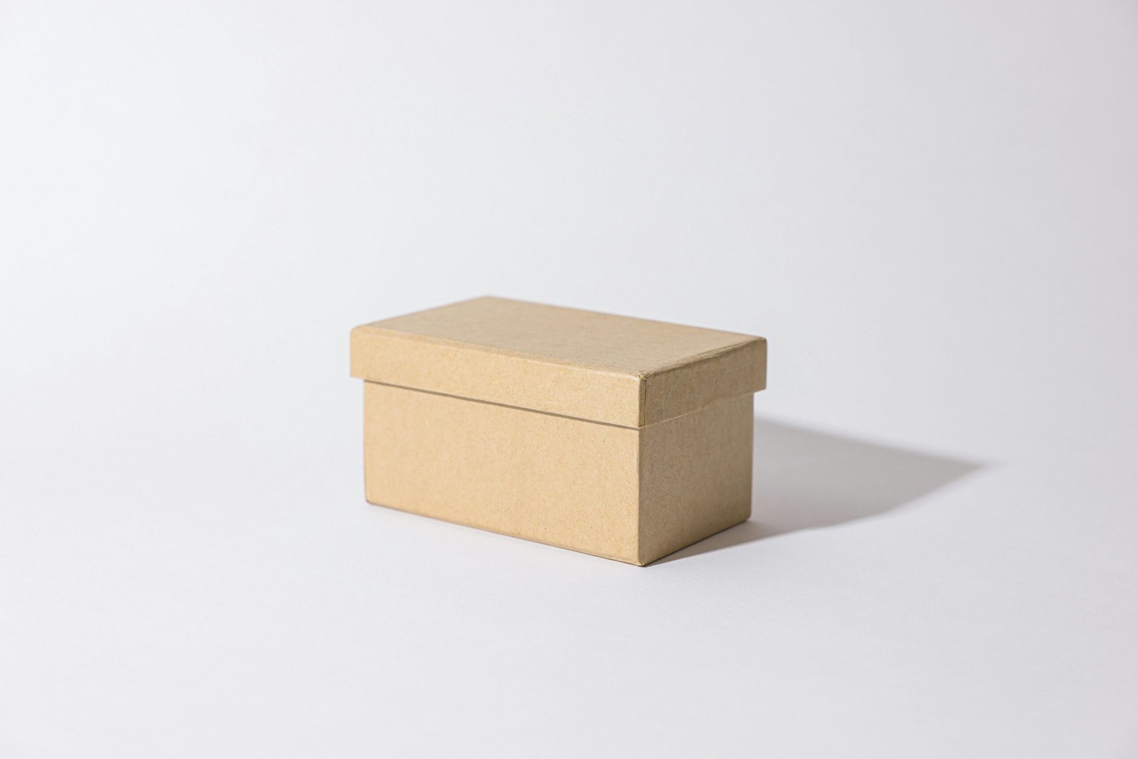 Close-up of a simple kraft box against a plain background, highlighting minimalist design.